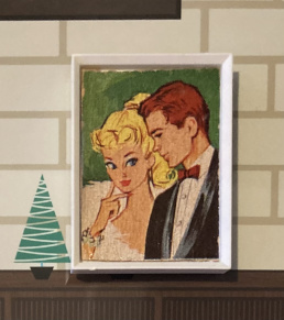 White frame "photo" of blonde ponytail Barbie in Enchanted Evening (probably--just the stole is visible) and Ken in a tux.
