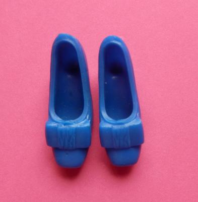 Royal blue bow shoes are displayed on a pink background