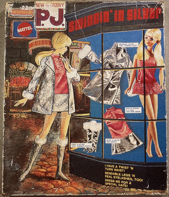 The P.J. Swingin' in Silver gift set exterior. About half the space is a lush illustration of a European street at night, with stone walls and rain-drenched cobblestones reflecting red lights from the cinema visible at the back; this may have been intended to evoke Carnaby Street or some other fashionable London locale. In the foreground, the illustrated P.J. stands gazing into a shop window, inside which photographs of of a silver jacket with white fur sleeves, a minidress with a pink top and silver skirt, and white-fur-trimmed, knee-length silver boots are arrayed on a solid blue background next to a photograph of the P.J. doll herself, wearing a bright pink micro-minidress, two ponytails, and her signature big round glasses. Labels hover above the photographed elements with descriptions like 'SMASHING SILVER "FUR" TRIMMED COAT!' "NEW 'N GROOVY P.J. DOLL/TINY PINK DRESS!" The illustrated P.J. is shown wearing the silver outfit, but she also appears tempted as she gazes at the garments in the window.