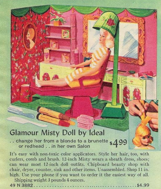 Color catalog image of Misty doll wearing a yellow striped dress, seated in a pink chair with green flowered dryer over her head. The rest of the play set is a cornered wall with counter and shelves long one side, depicting mirror, flowered wallpaper, and portraid of blonde woman in profile. Floor is green and walls are mainly red-pink. Also shown are comb, brush, hair markers and rollers. Test reads, "Glamour Misty Doll by Ideal..change her from a blonde to a brunette or redhead..in her own Salon $4.99; It's easy with non-toxic color applicators. Style her air, too, with curlers, comb and brush. 12-inch Misty wears a sheath dress, shoes; can wear most 12-inch doll outfits. Chipboard beauty shop with chair, dryer, counter, sink and other items. Unassembled. Shop 11 in. high. Use your phone if you want to order it the easiest way of all. Shipping weight 3 pounds 4 ounces. 49 N 3882.....$4.99."
