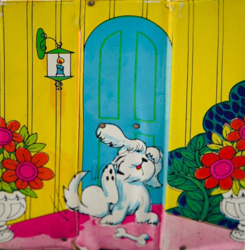 Illustration of a shaggy, white dog from the exterior of the first World of Barbie family house. The dog is scratching one ear with a back paw; a bone sits in front of it. Behind it is an arched, blue door in a yellow wall, and potted flowers and other foliage sit to either side.