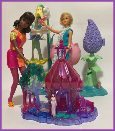 Two dolls are posed with plastic Fairytopia play sets from the early 2000s. One in the foreground is "jewel"-like translucent plastic. The Hallmark mini Enchanted Evening stands at the front door of a structure and is roughly the same height as the doorway. The playset in the background looks like a row of flowers and is even taller than Casey, who stands next to it.