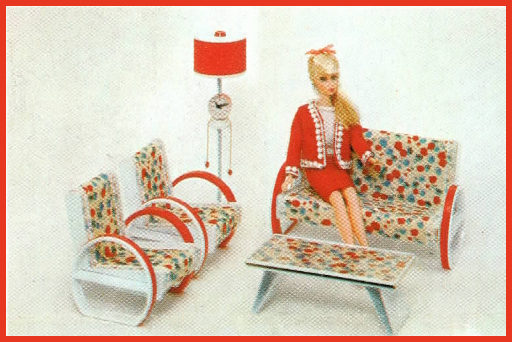 Grainy color photograph of blonde TnT Barbie in a skirt-suit of red fabric lined with white trim and white shell, sitting on a sofa printed with fauvist blue-and-red abstracted flower shapes. The arms of the sofa are almost like wheels with flat bottoms, made with white plastic outlined in red. Next to her are two chairs in the same style, and in front is a rectangular coffee table with the same fauvist print atop, and legs that look like hairpin legs from one angle but span the width of the table. Rounding out the scene is a floor lamp, also in white, with drum-shaped red shade. Midway up the side is what looks like a little table supporting a round clock.