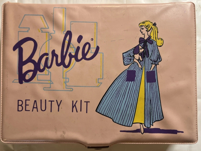Vinyl case in a pinkish shade with a color illustration of Barbie in her ensemble Nighty Negligee (1959-1964) in new colors. THe nightgown is yellow (her ponytail is the same shade) and the peignoir is blue with purple or navy stripes, with two patch pockets and a ribbon tied and neckline in the same shade. She holds the stuffed dog included in the set. Beside her is the familiar Barbie logo above the words "Beauty Kit" in all caps, somewhat unaligned in the vertical so each letter rises or falls slightly relative to its neighbors. Behind the Barbie signature are three outlines or silhouettes of glass bottles with lids in light blue with a stripe of tellow up the right sidfe of each, like an abstaction of light hitting glass.